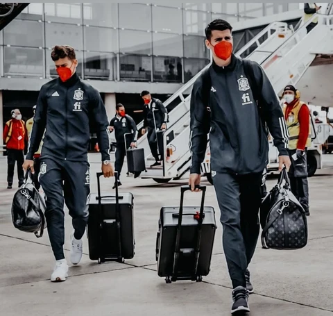 Traveling sports team carrying portable gaming cases at an airport