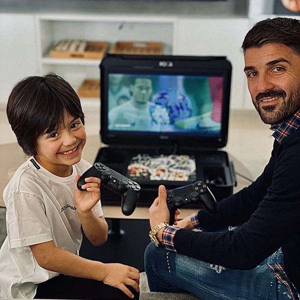 David Villa and a child using an open POGA portable Xbox gaming station
