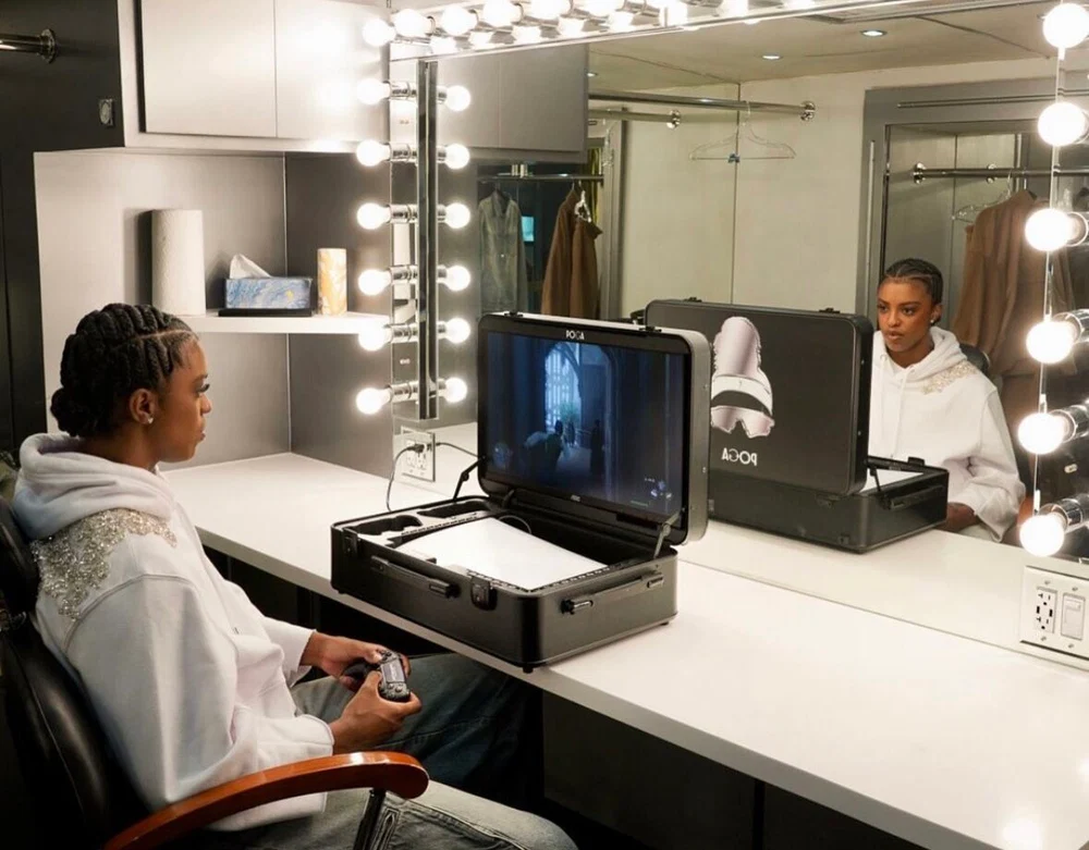 Portable gaming station open beside a vanity mirror with a gamer using a controller