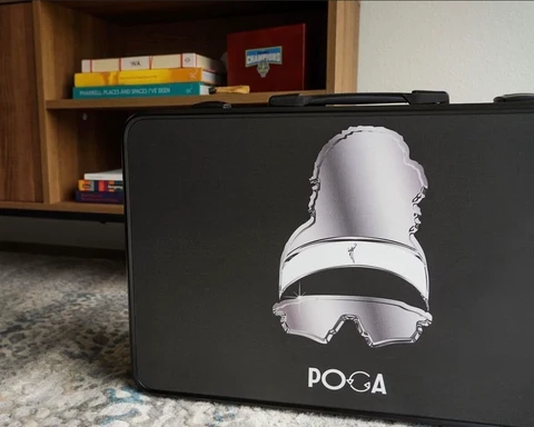Closed POGA gaming case resting on a floor beside a bookshelf